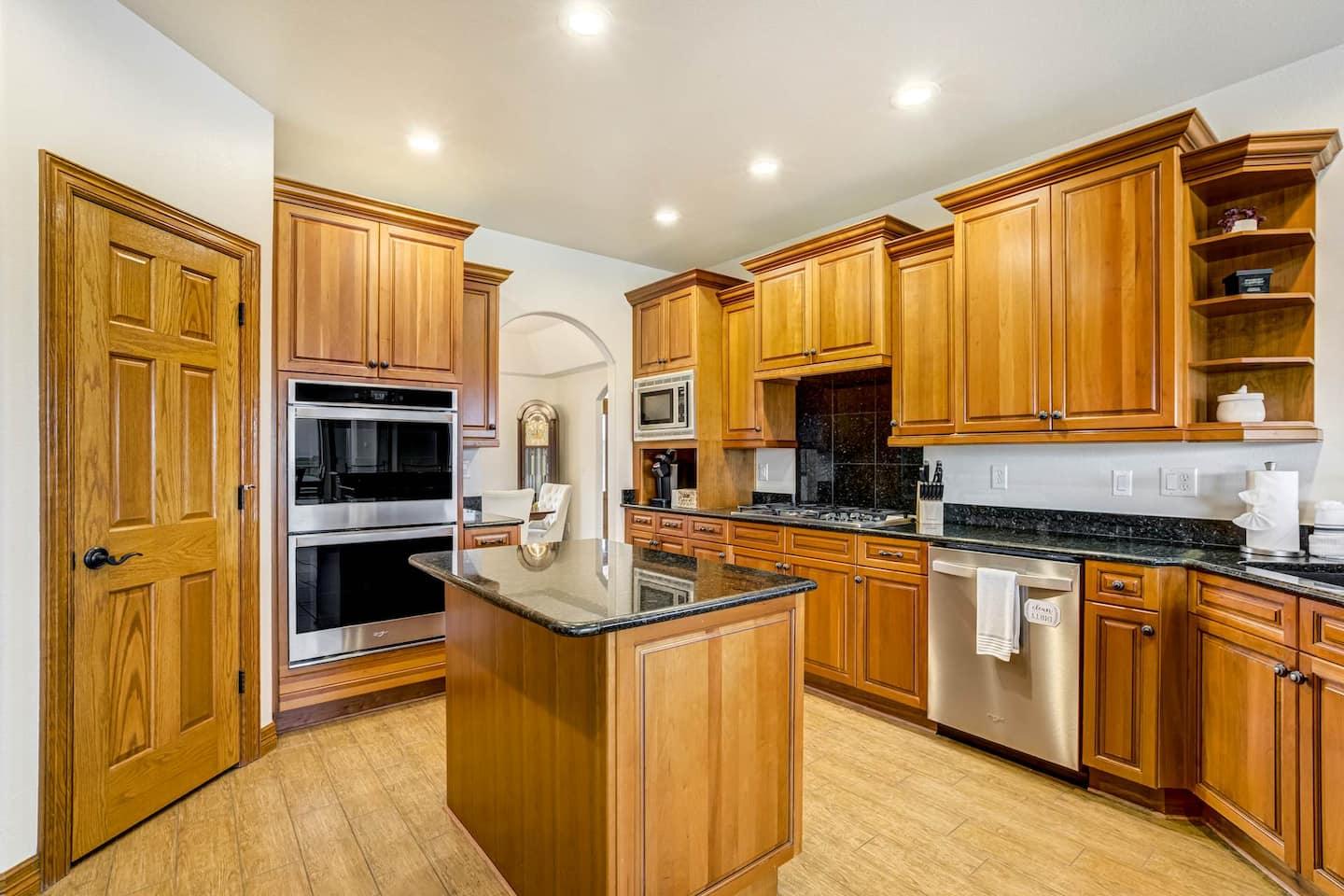 Kitchen with wood cabinetry, double wall ovens and a center island