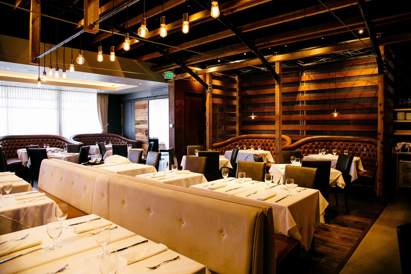 The Cowboy Star dining room in Colorado Springs, with tufted leather booths under warm Edison bulbs