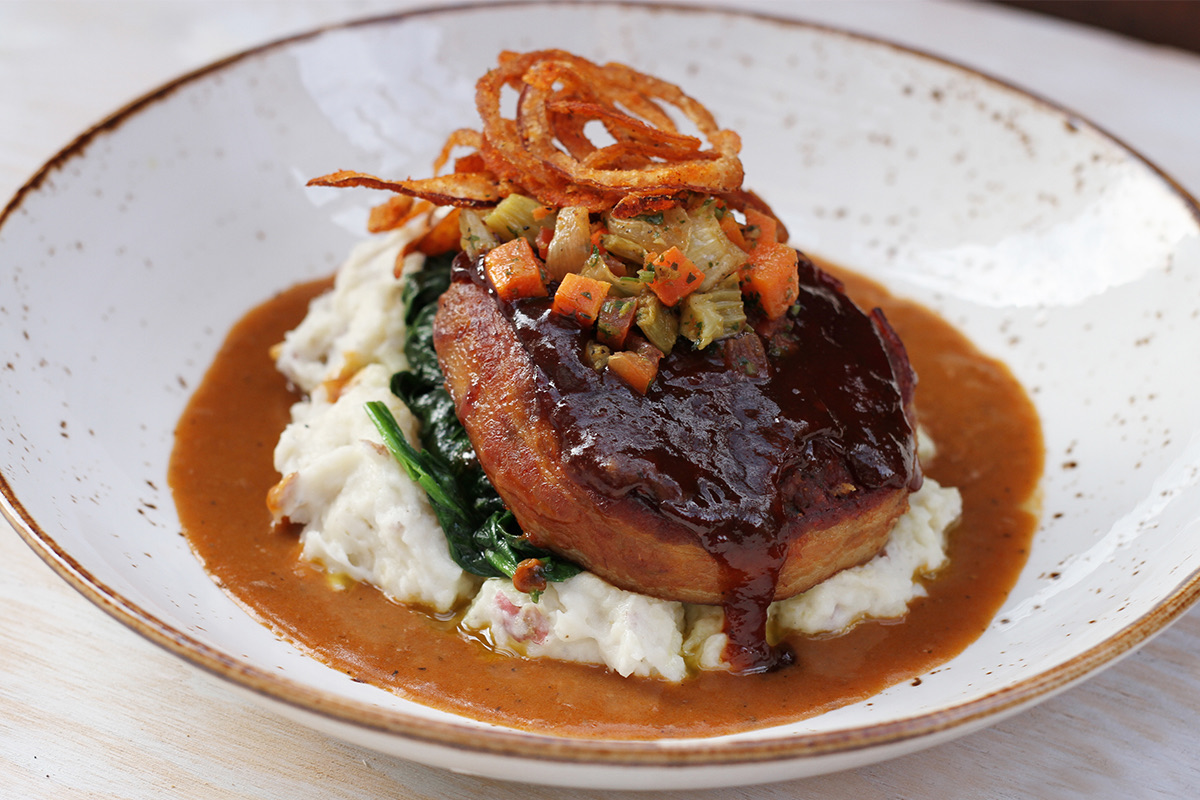 Lazy Dog's BBQ bison meatloaf on mashed potatoes with spinach, gravy and crispy onions